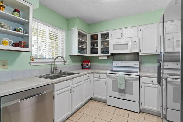 a kitchen with stainless steel appliances granite countertop a sink window and cabinets