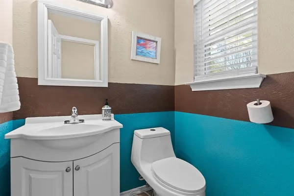 a bathroom with a toilet a sink and a window