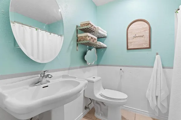 a bathroom with a toilet sink and mirror