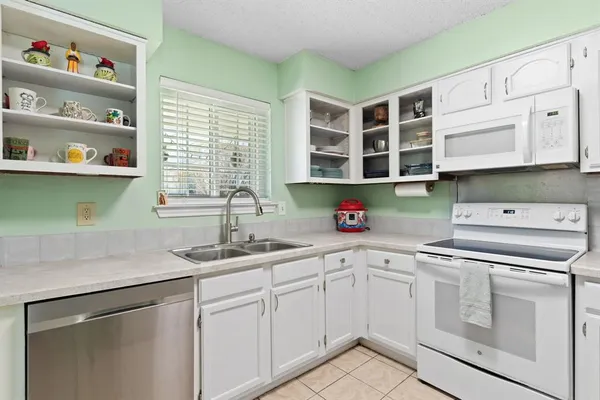 a kitchen with stainless steel appliances white cabinets and a sink