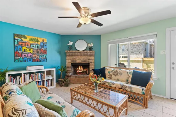 a living room with furniture a fireplace and a large window