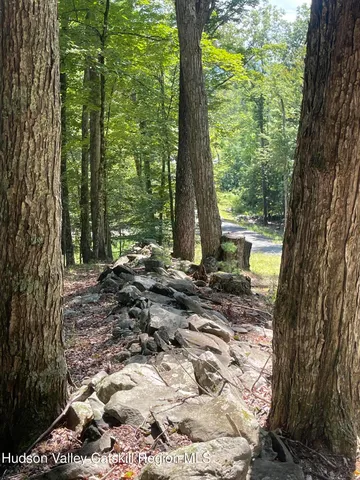 a backyard of a house with large trees and outdoor seating
