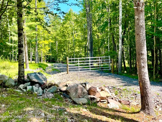 a view of backyard with wooden fence and trees