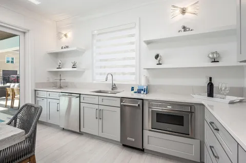 a large kitchen with kitchen island a stove a sink a dining table and chairs