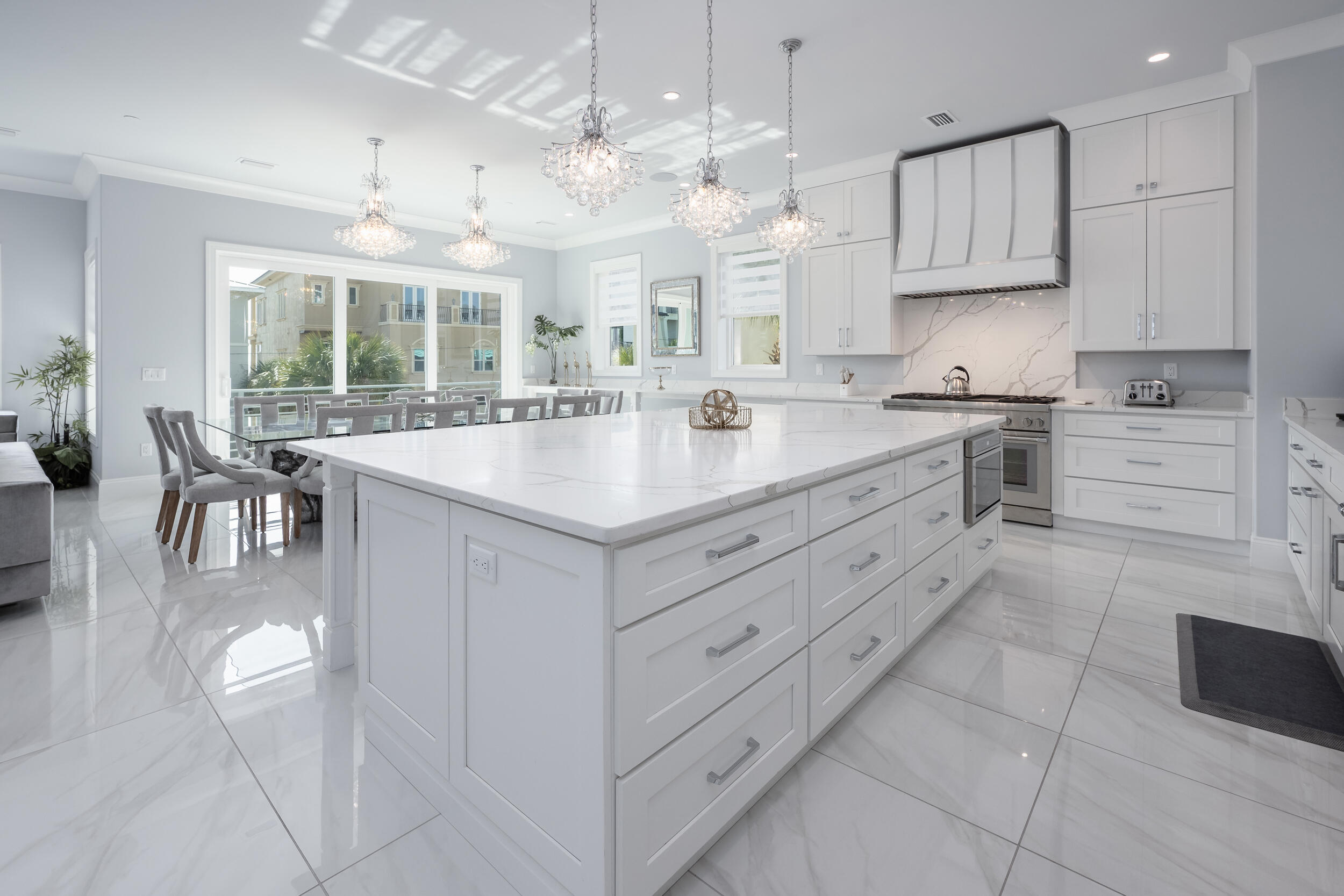 244 Open Gulf Street Miramar Beach, FL 32550 - Photo 41 of 151 a large kitchen with kitchen island a stove a sink a dining table and chairs