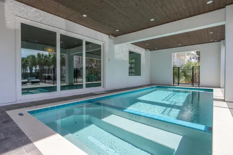 a bedroom with a bed a flat screen tv and a large window