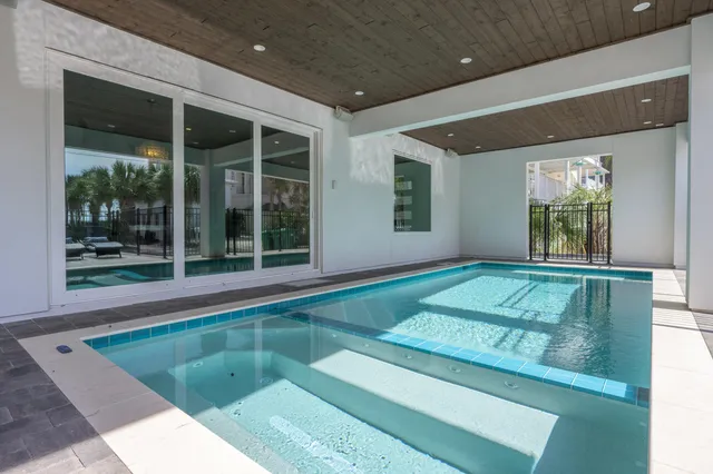 a bedroom with a bed a flat screen tv and a large window