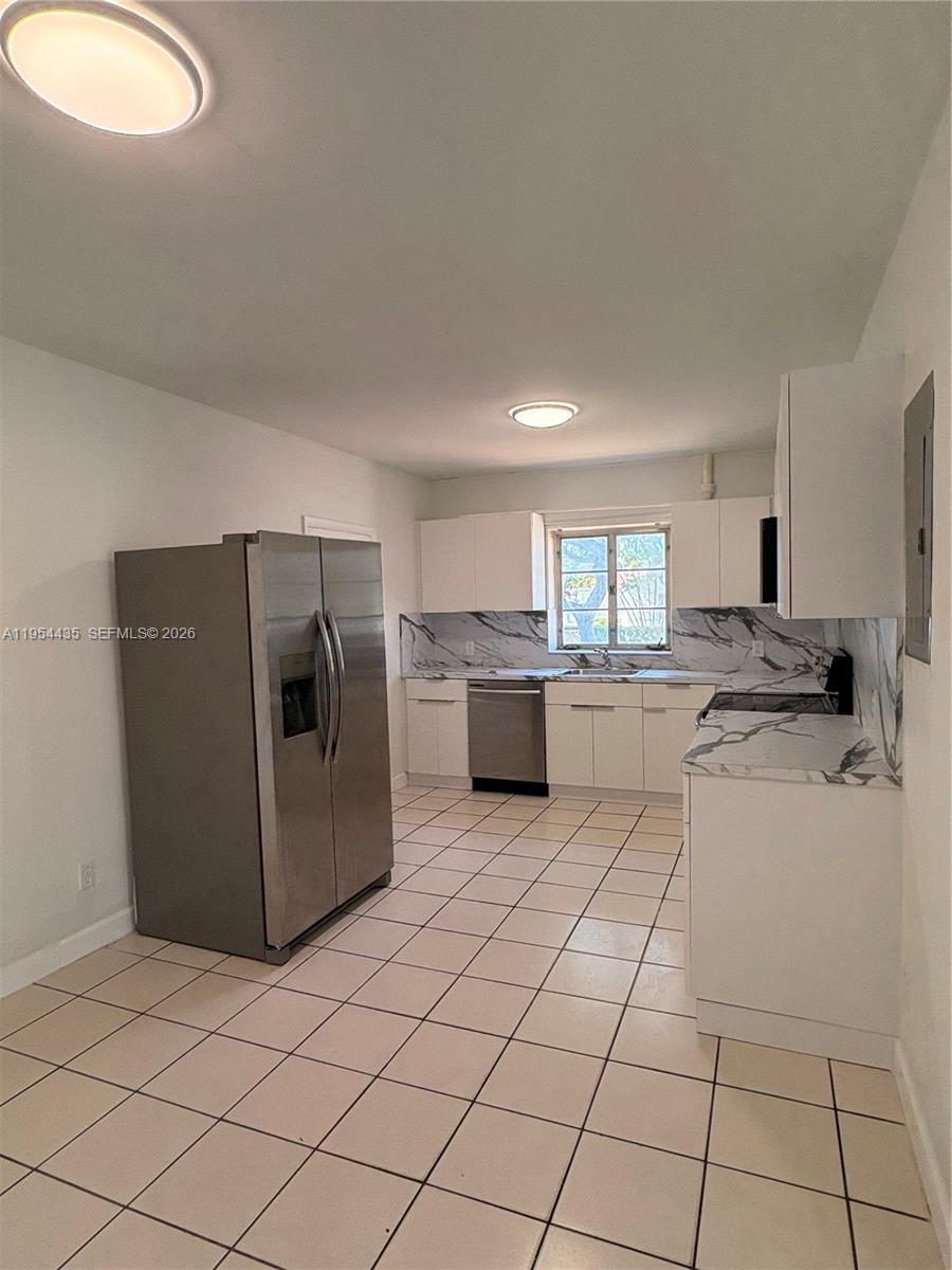 2390 Northwest 30th Street Miami, FL 33142 - Photo 4 of 11 a kitchen with a refrigerator sink and cabinets