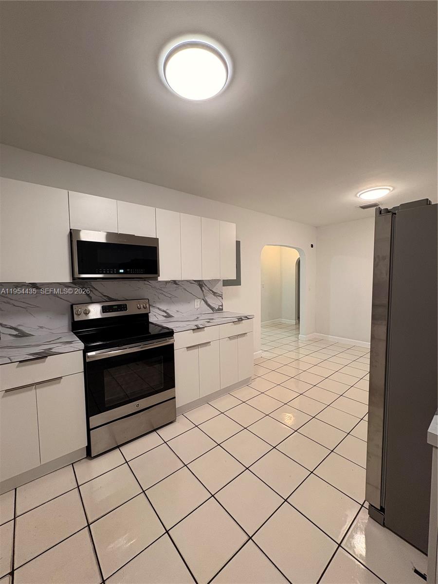 2390 Northwest 30th Street Miami, FL 33142 - Photo 5 of 11 a kitchen with a stove a sink and a refrigerator