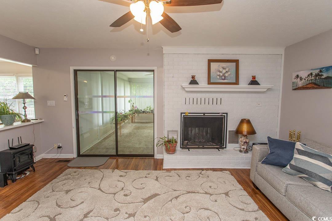 18 Pine Valley Lane Surfside Beach, SC 29575 - Photo 13 of 35 Living area featuring a wood stove, ceiling fan, and wood finished floors