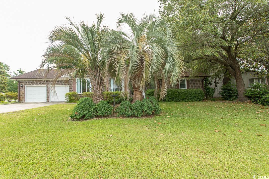 18 Pine Valley Lane Surfside Beach, SC 29575 - Photo 27 of 35 View of property hidden behind natural elements with concrete driveway, an attached garage, a front lawn, and brick siding