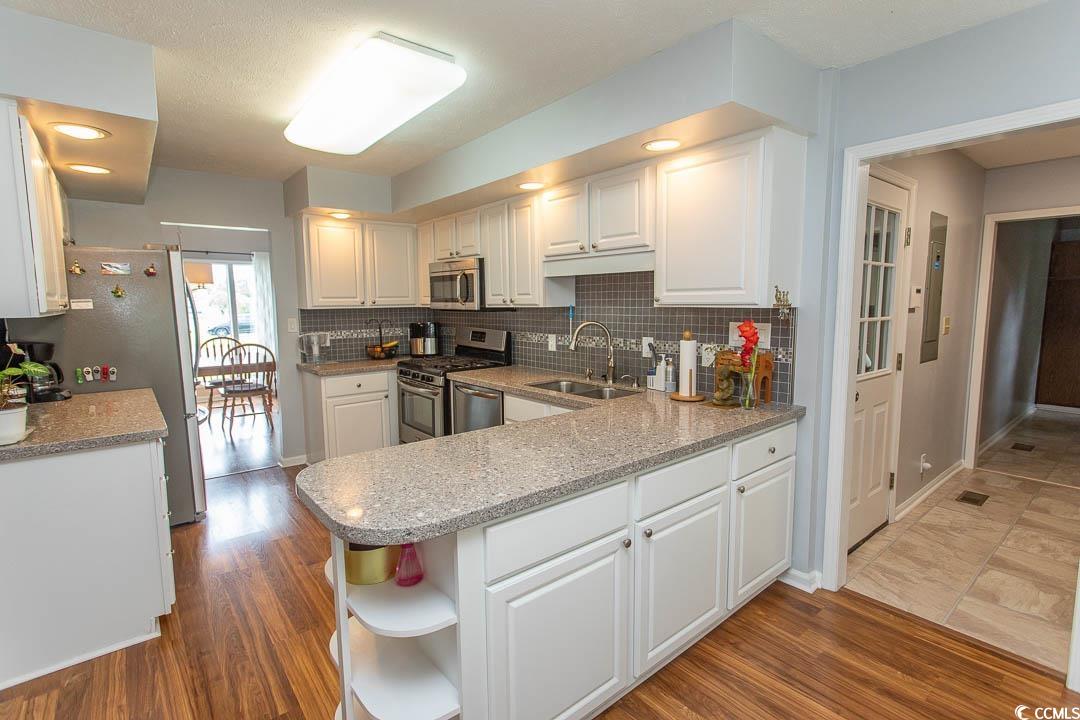 18 Pine Valley Lane Surfside Beach, SC 29575 - Photo 3 of 35 Kitchen featuring a sink, stainless steel appliances, white cabinets, tasteful backsplash, and open shelves