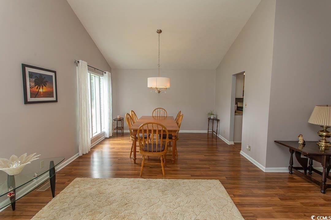 18 Pine Valley Lane Surfside Beach, SC 29575 - Photo 10 of 35 Dining room with vaulted ceiling, wood finished floors, baseboards, and a chandelier