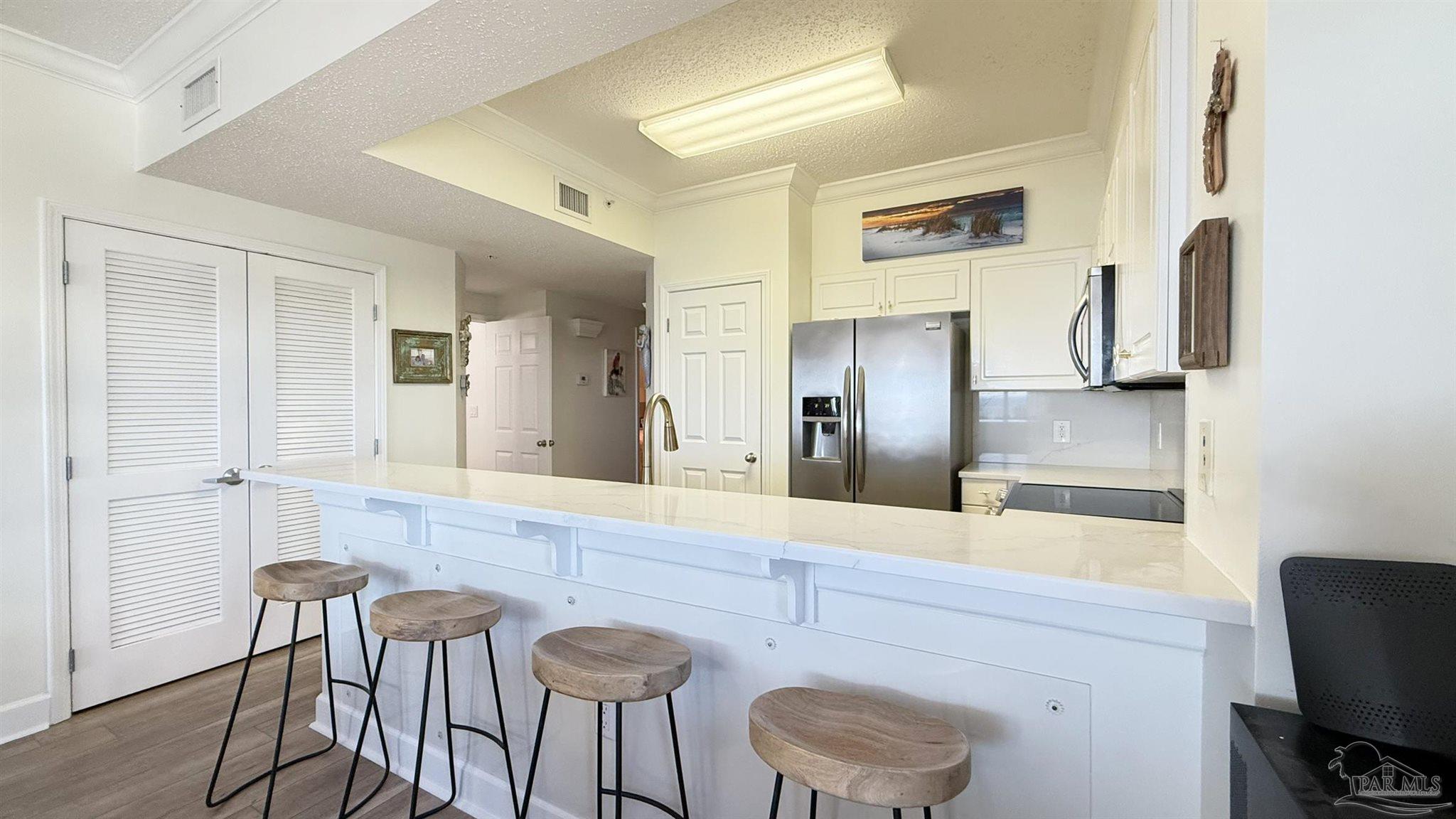 14511 Perdido Key Drive, Unit 1301 Perdido Key, FL 32507 - Photo 23 of 65 a kitchen with stainless steel appliances granite countertop a refrigerator and a stove top oven