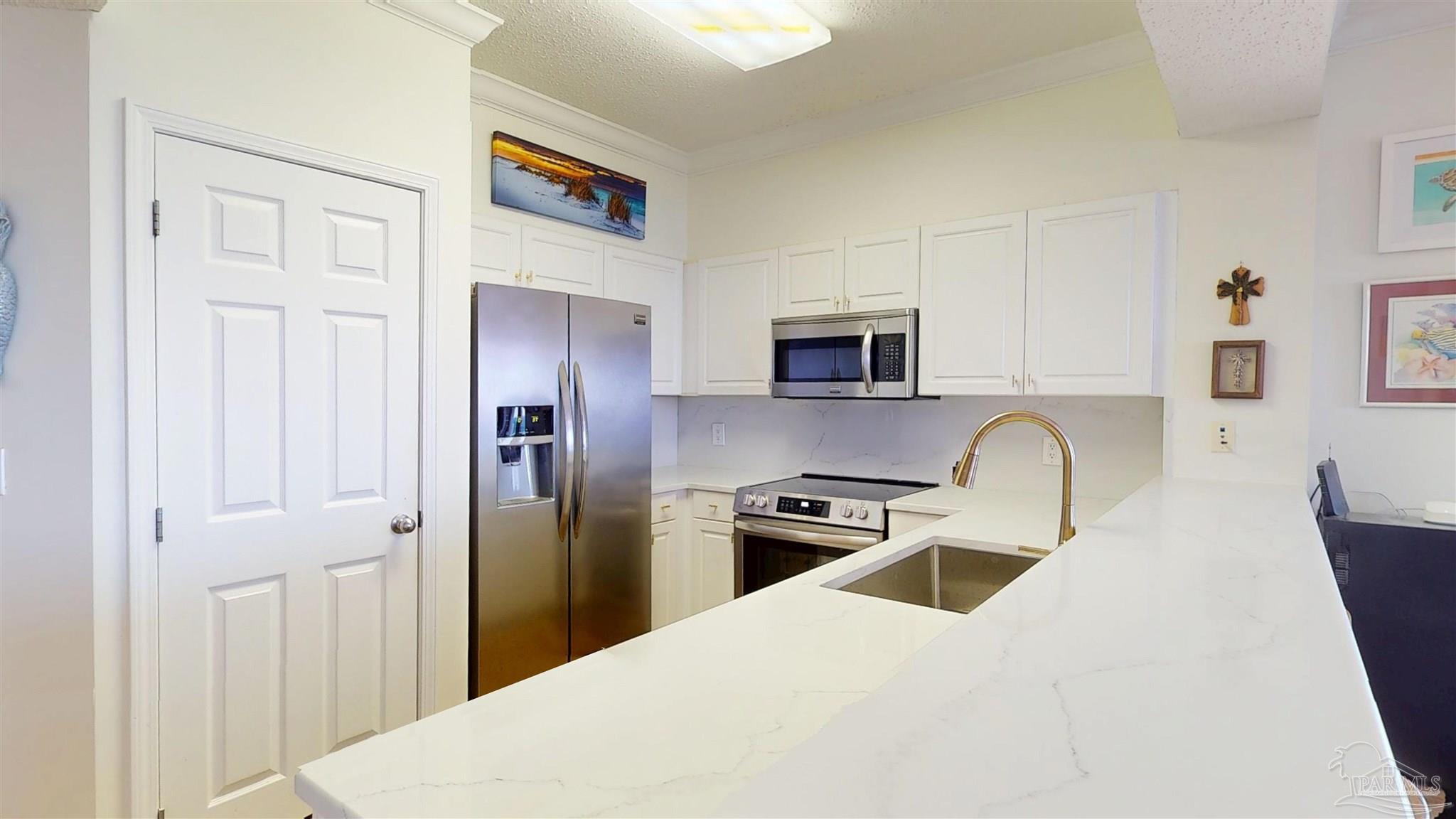 14511 Perdido Key Drive, Unit 1301 Perdido Key, FL 32507 - Photo 25 of 65 a kitchen with stainless steel appliances a refrigerator stove microwave and sink