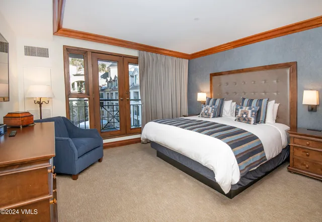 a spacious bedroom with a bed and a couch next to a window