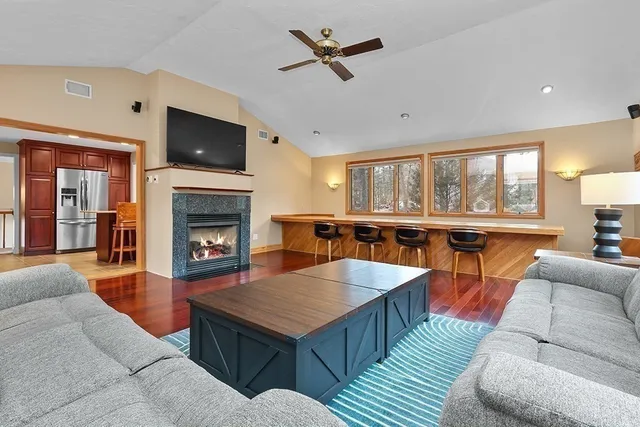 a living room with furniture a fireplace and a flat screen tv