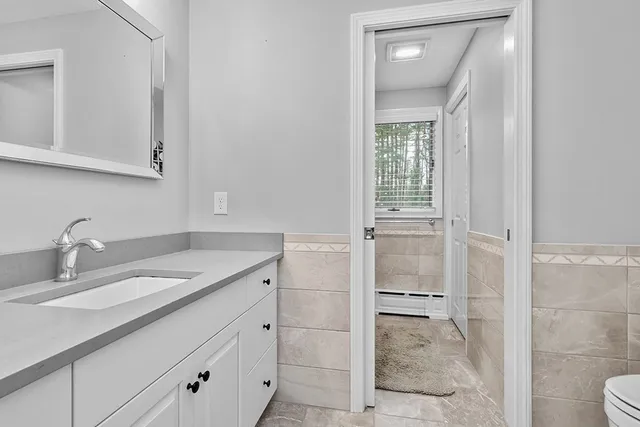 a bathroom with a granite countertop sink a vanity and a window