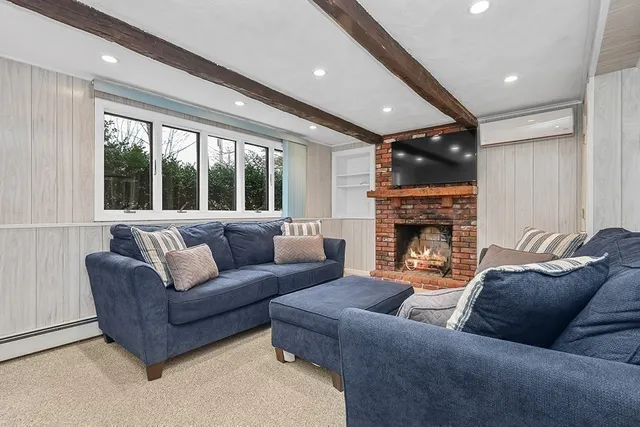 a living room with furniture a fireplace and a large window