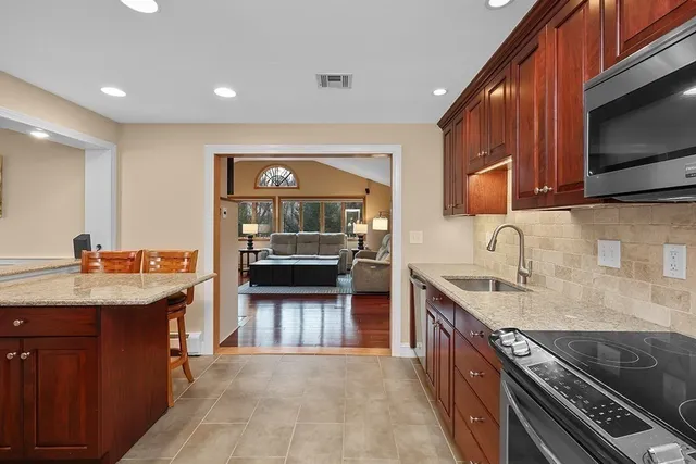 a kitchen with granite countertop a sink and stove top oven