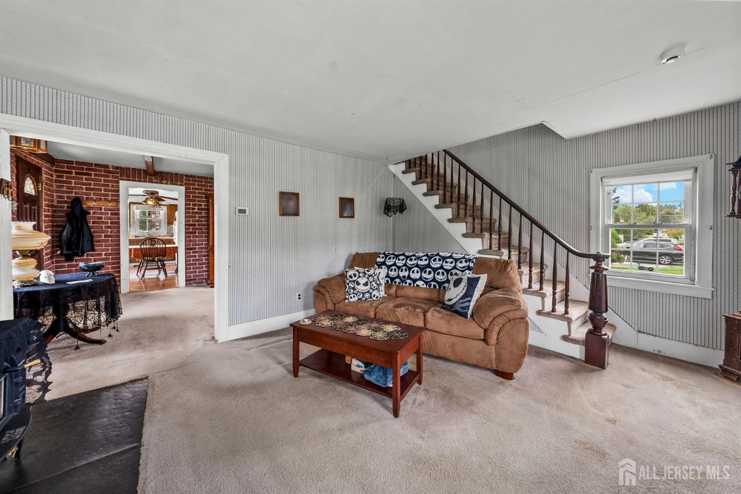 202 Ravine Drive Matawan, NJ 07747 - Photo 15 of 41 a living room with furniture and a dining table next to a window