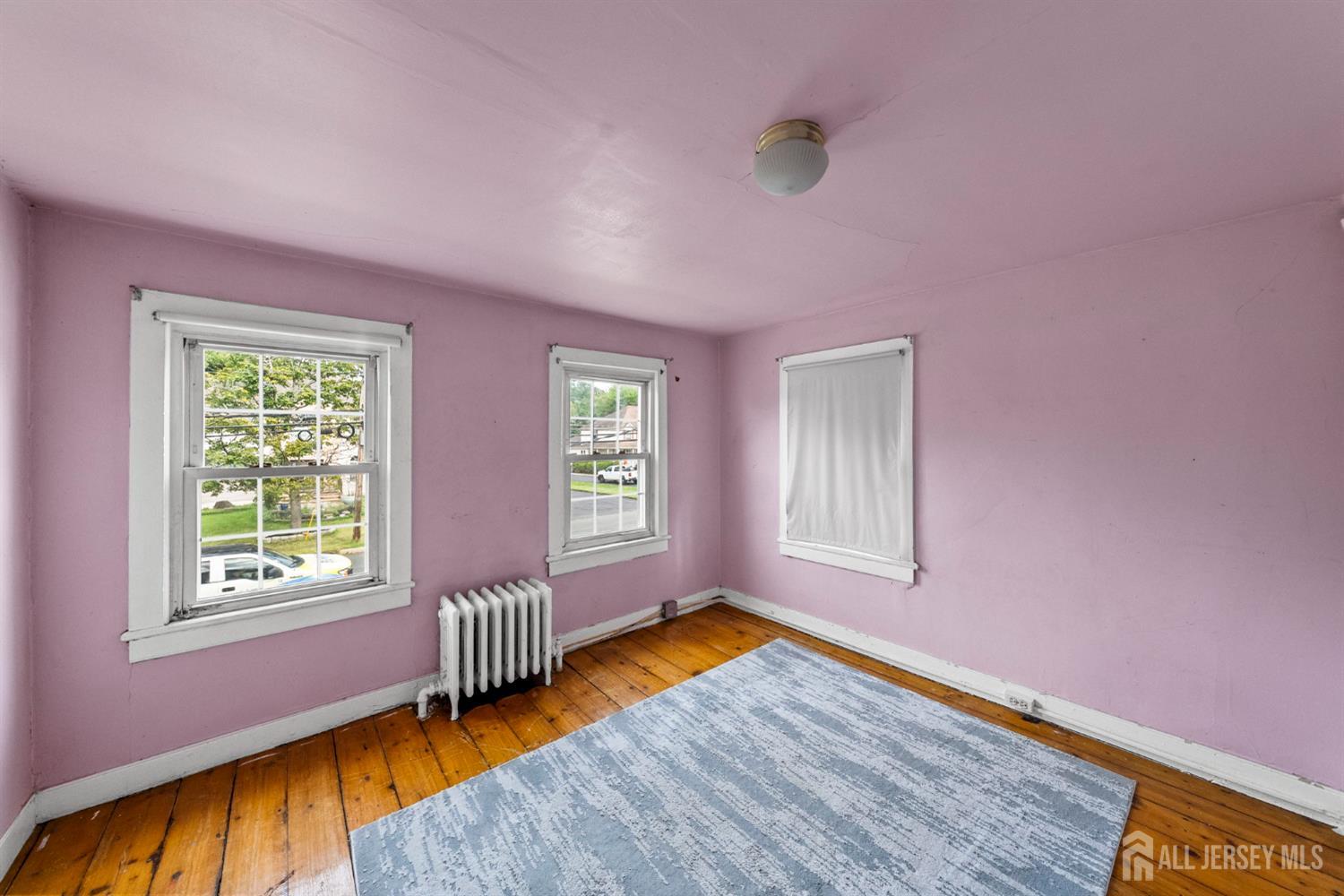 202 Ravine Drive Matawan, NJ 07747 - Photo 22 of 41 a bedroom with a bed and wooden floor