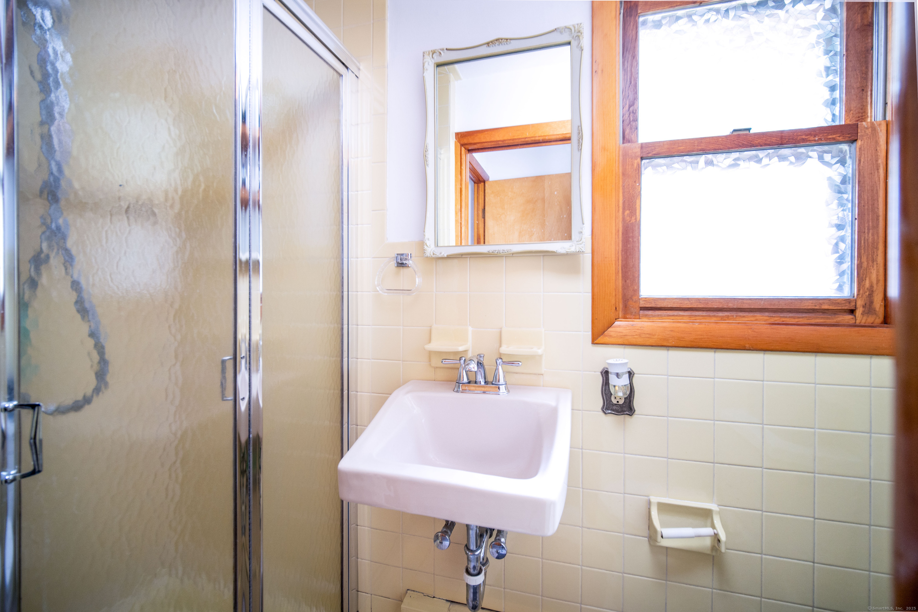 147 Funston Avenue Torrington, CT 06790 - Photo 15 of 40 a bathroom with a sink a mirror and a window