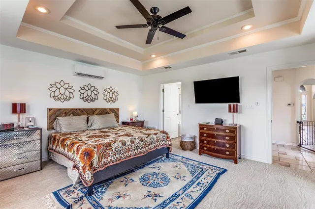 a bedroom with a bed a flat screen tv and a couch