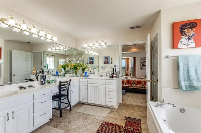 a large white kitchen with a white countertops a stove and a sink