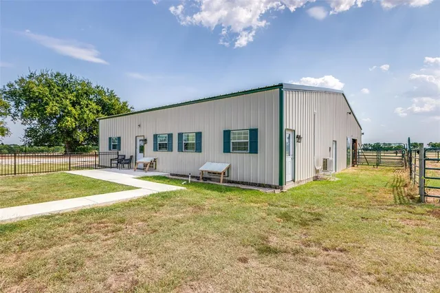 a view of a house with backyard and a tree