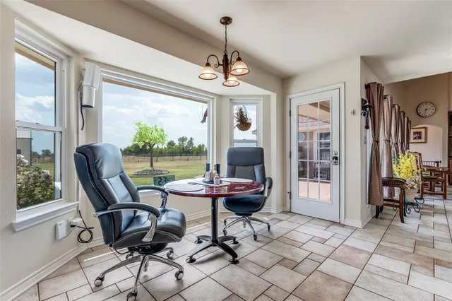 a dining room with furniture a chandelier and glass door