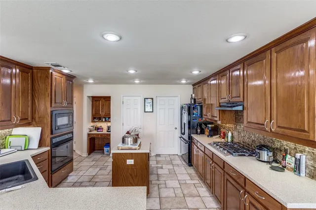a large kitchen with stainless steel appliances granite countertop a stove and a sink