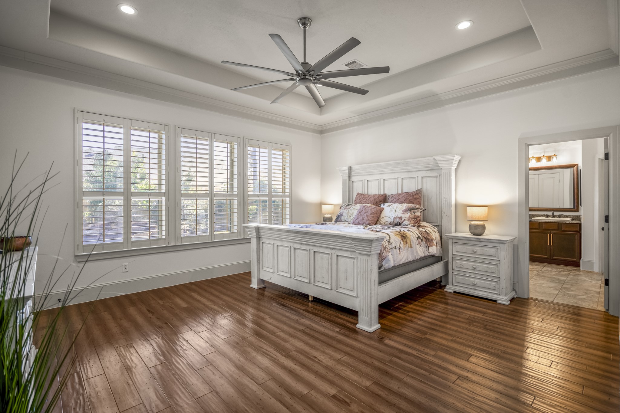 3710 Snowden Point Lane Spring, TX 77386 - Photo 17 of 50 This spacious primary suite features elegant floors, a high ceiling with a modern fan, and large windows with plantation shutters for ample natural light.