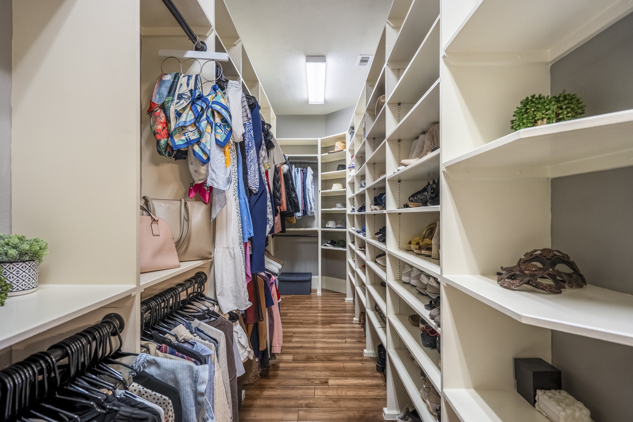 3710 Snowden Point Lane Spring, TX 77386 - Photo 19 of 50 The stunning primary walk-in closet is equipped with ample shelving and hanging space. It features organized clothing racks, shoe storage and wood flooring, offering a tidy and elegant storage solution.