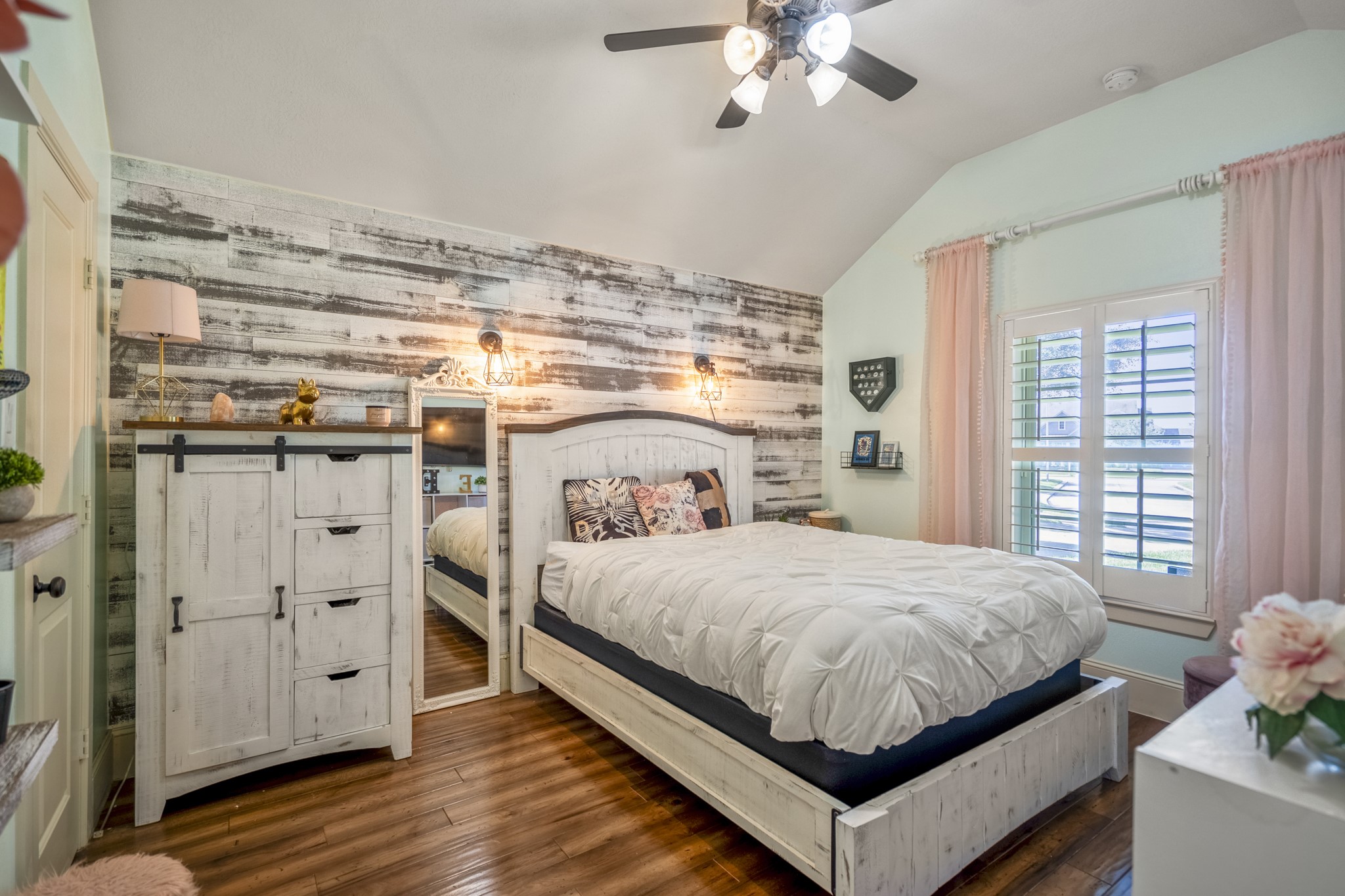 3710 Snowden Point Lane Spring, TX 77386 - Photo 24 of 50 1 of 2 secondary bedrooms, featuring an accent wall and brightened by natural light from large windows with plantation shutters, complimented with warm wood flooring.