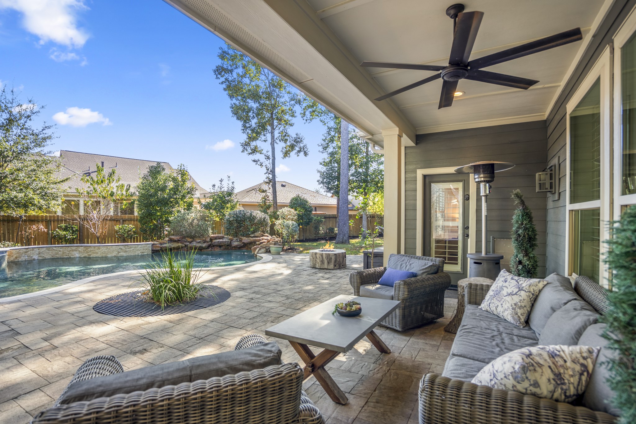 3710 Snowden Point Lane Spring, TX 77386 - Photo 31 of 50 Unwind your days under the covered patio featuring comfortable seating and a ceiling fan. This serene space overlooks the pool surrounded by lush landscaping, creating a private and relaxing outdoor oasis.