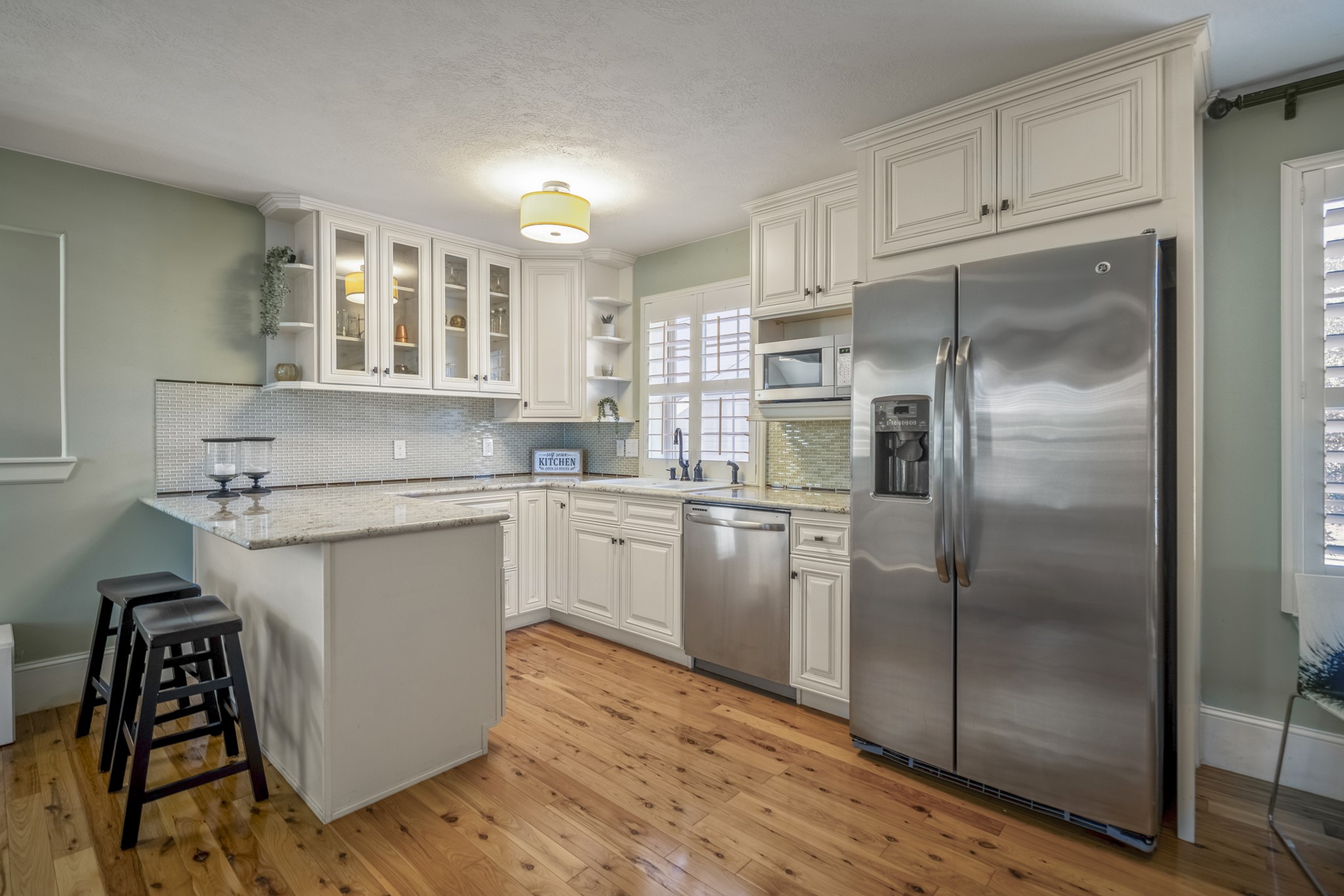 3710 Snowden Point Lane Spring, TX 77386 - Photo 37 of 50 This GUEST SUITE kitchen features elegant white cabinetry with glass fronts, stainless steel appliances, and a spacious granite countertop. The room is brightened by natural light with windows throughout.