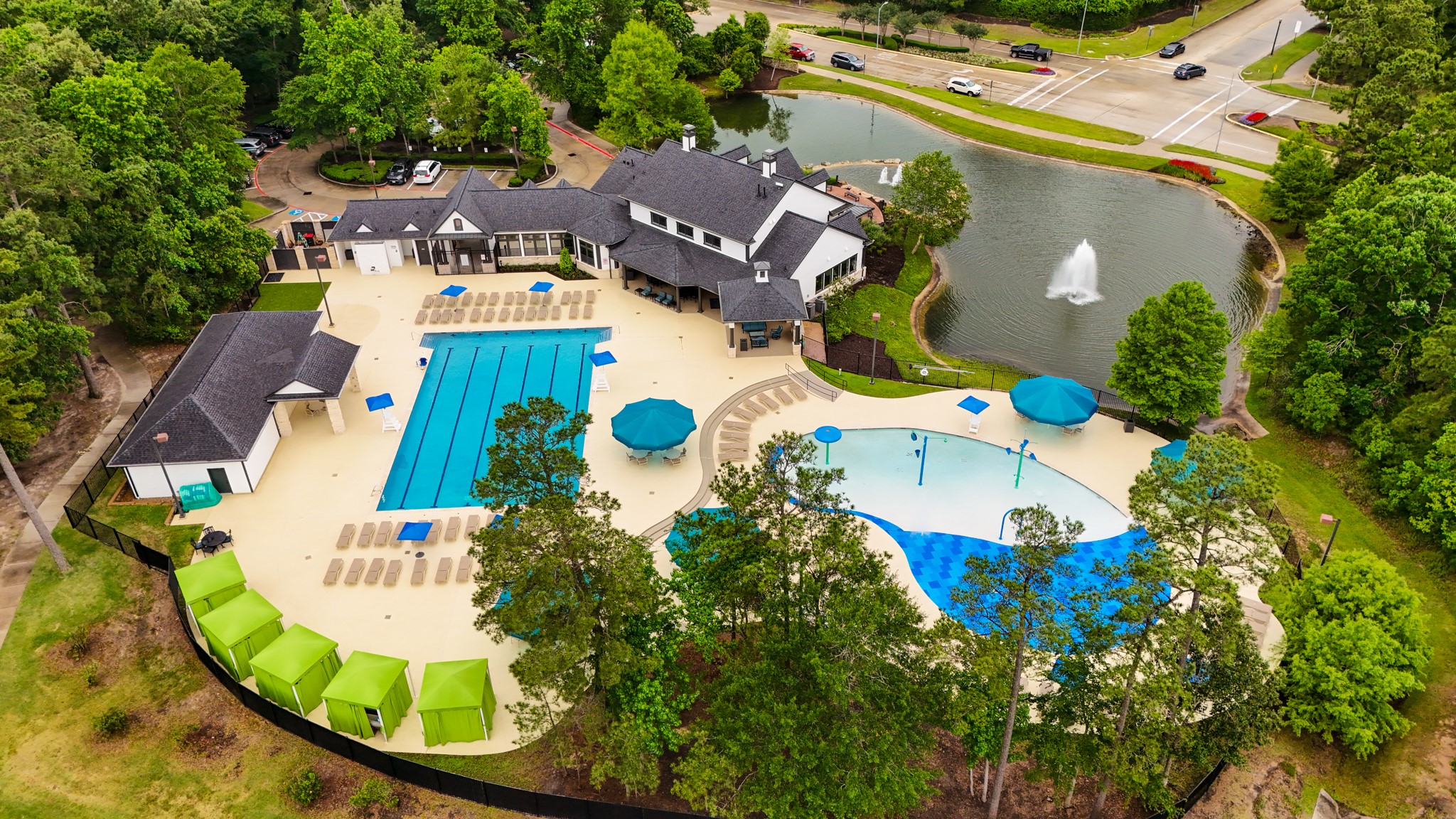 3710 Snowden Point Lane Spring, TX 77386 - Photo 46 of 50 Enjoy this community recreational area with a large swimming pool, a children's splash pad, cabanas and a clubhouse. It's set in a lush, green environment with a nearby pond and fountain, offering a serene and enjoyable setting for residents.