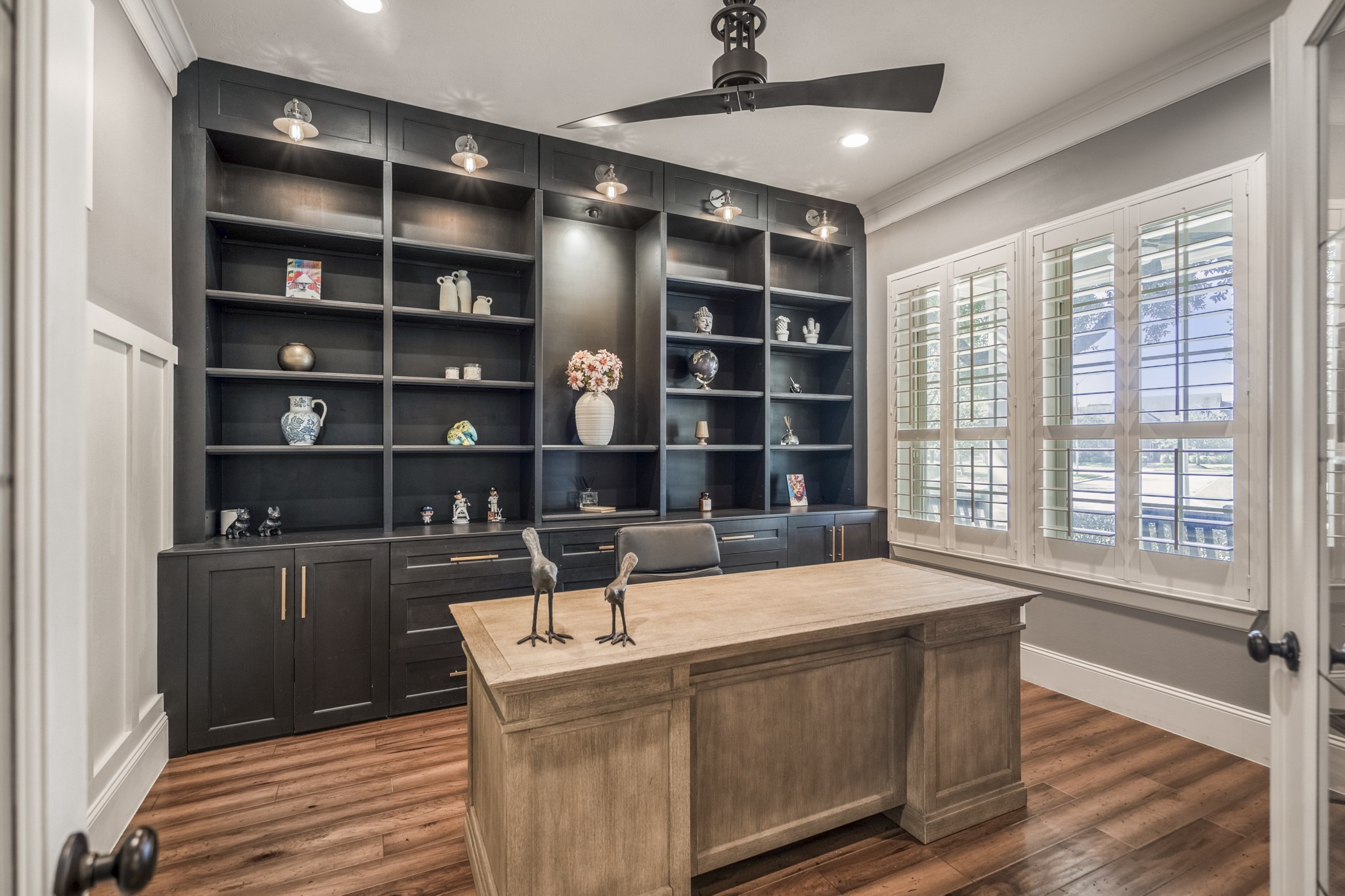 3710 Snowden Point Lane Spring, TX 77386 - Photo 5 of 50 This stylish home office with built-in shelving benefits from ample natural light and plantation shutters. The dark cabinetry contrasts with the warm wooden flooring tastefully.
