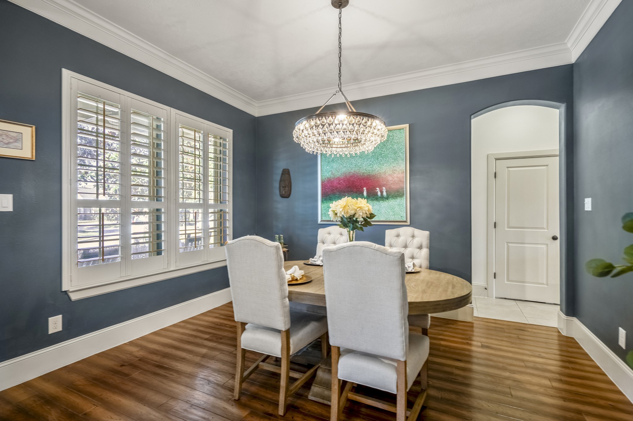 3710 Snowden Point Lane Spring, TX 77386 - Photo 10 of 50 This dining room features elegant walls and warm wood flooring, highlighted by a stylish chandelier. Large windows with plantation shutters offer ample natural light, and the space is accented with beautiful trim.