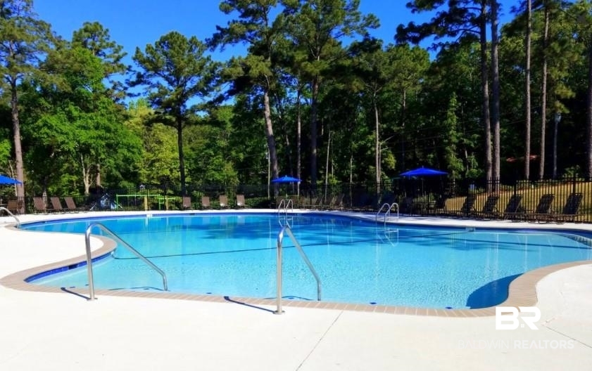 209 Montclair Loop Daphne, AL 36526 - Photo 8 of 55 Community pool featuring fence, view of scattered trees, and a patio