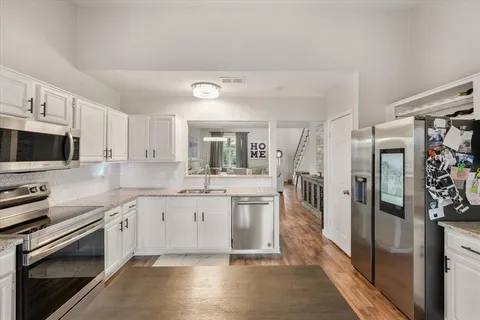 a large kitchen with cabinets and stainless steel appliances