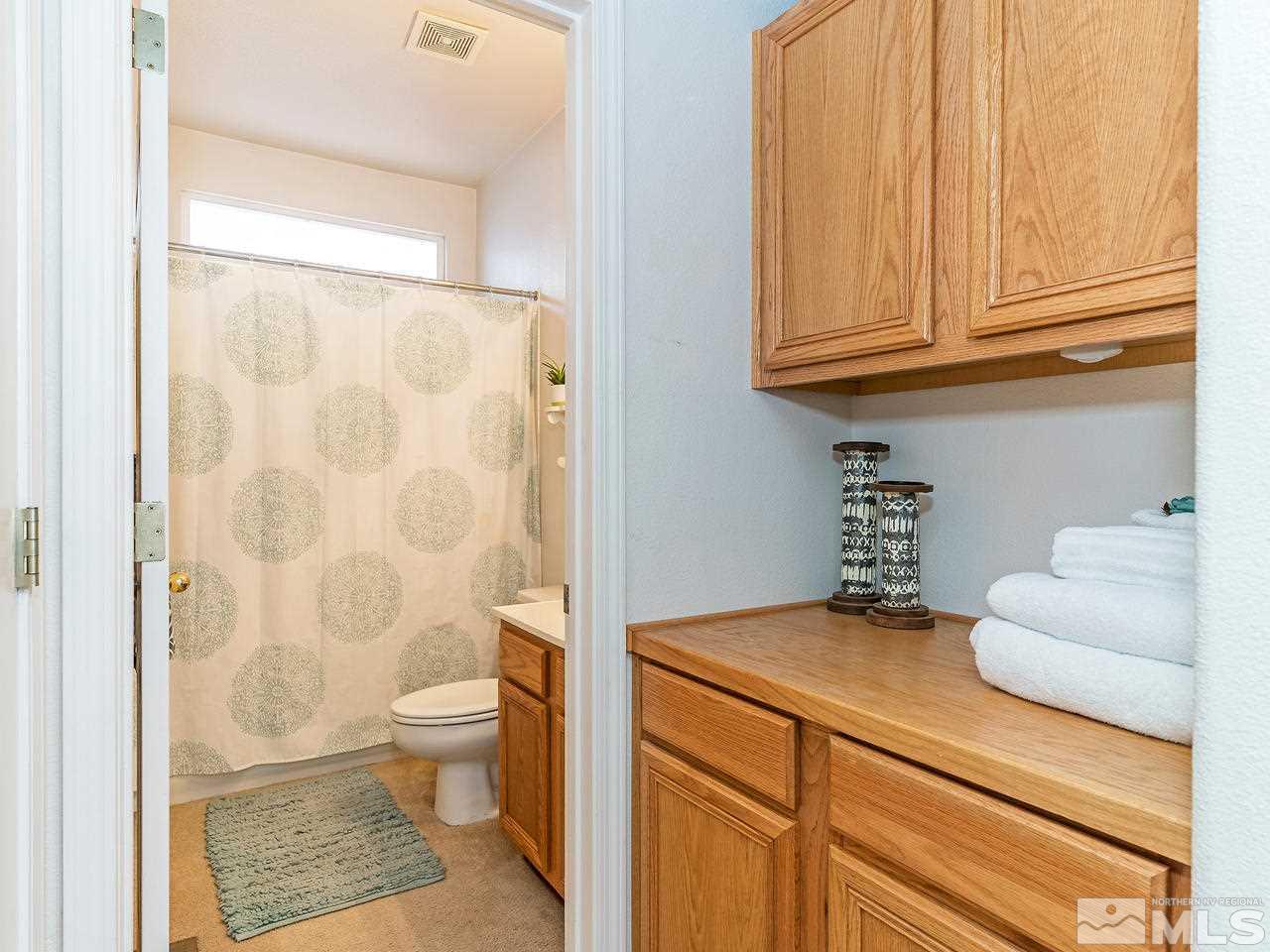 875 Caughlin Crossing Reno, NV 89519 - Photo 14 of 21 a bathroom with a granite countertop sink a toilet and a shower