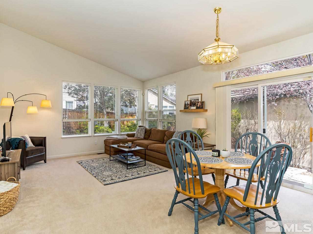 875 Caughlin Crossing Reno, NV 89519 - Photo 4 of 21 a dining room with furniture a chandelier and a rug