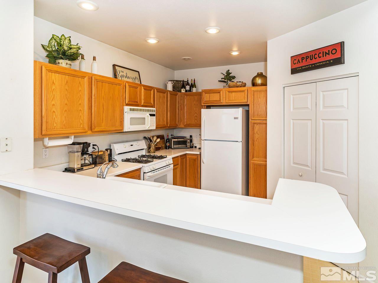 875 Caughlin Crossing Reno, NV 89519 - Photo 9 of 21 a kitchen with stainless steel appliances a refrigerator a sink a stove a microwave a counter top and cabinets