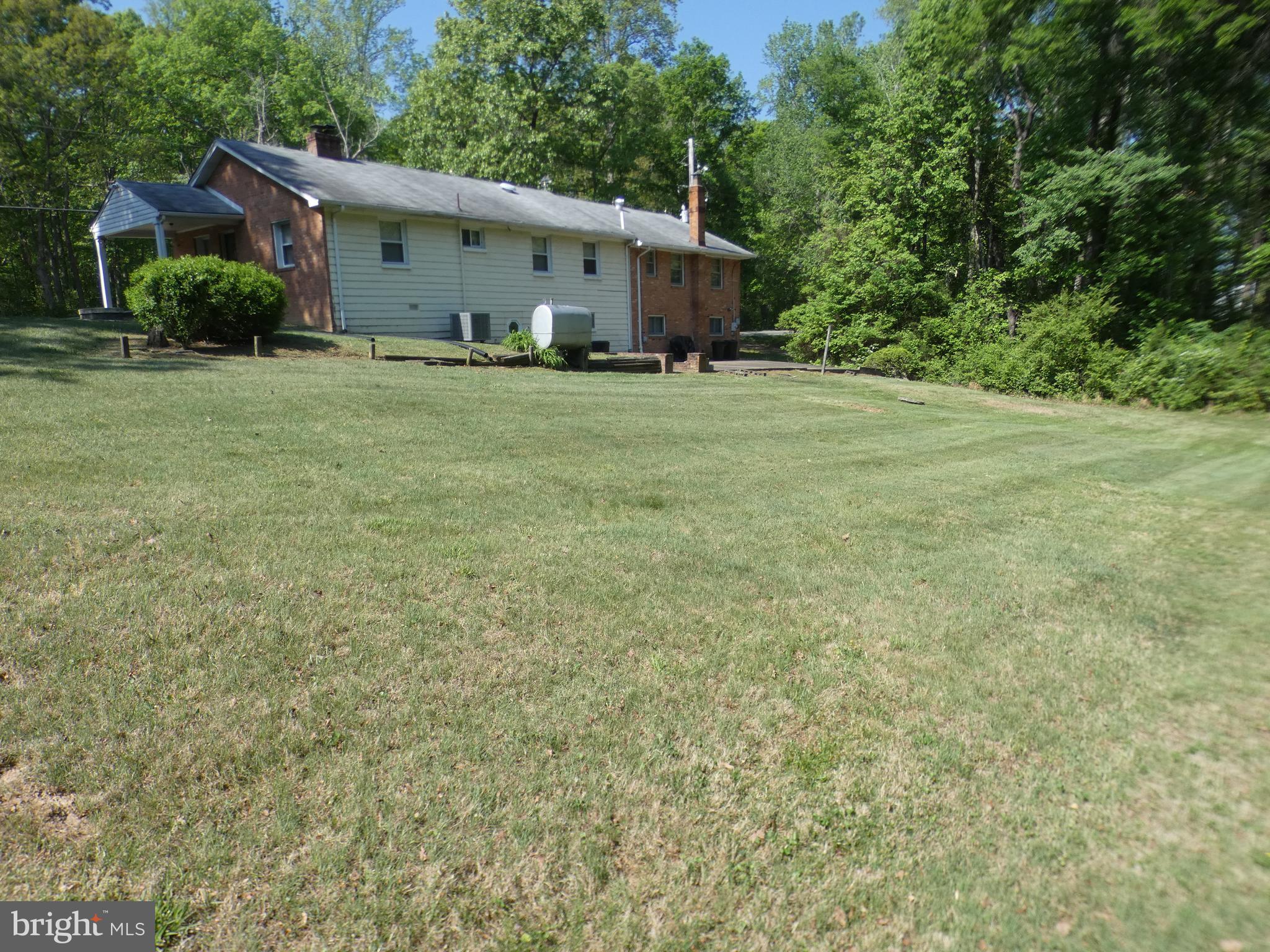 9517 Brock Road Spotsylvania, VA 22553 - Photo 23 of 27 a big house with a big yard and large trees