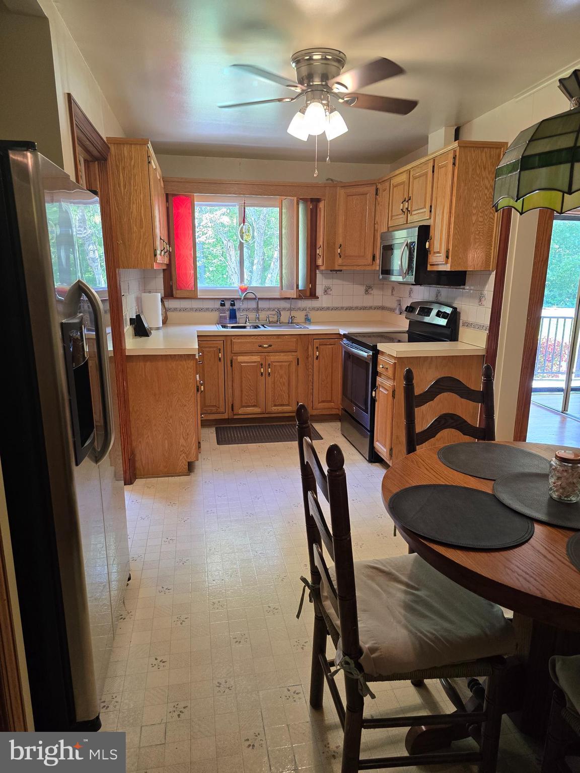 9517 Brock Road Spotsylvania, VA 22553 - Photo 8 of 27 a kitchen with stainless steel appliances granite countertop a refrigerator a sink dishwasher a stove a dining table and chairs with wooden floor
