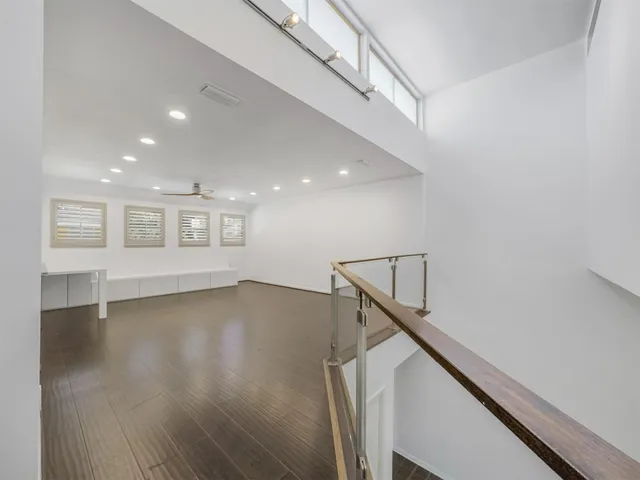 a view of a livingroom with wooden floor and stairs