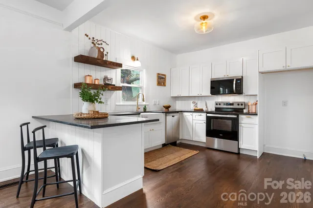 a kitchen with granite countertop stainless steel appliances a sink and cabinets