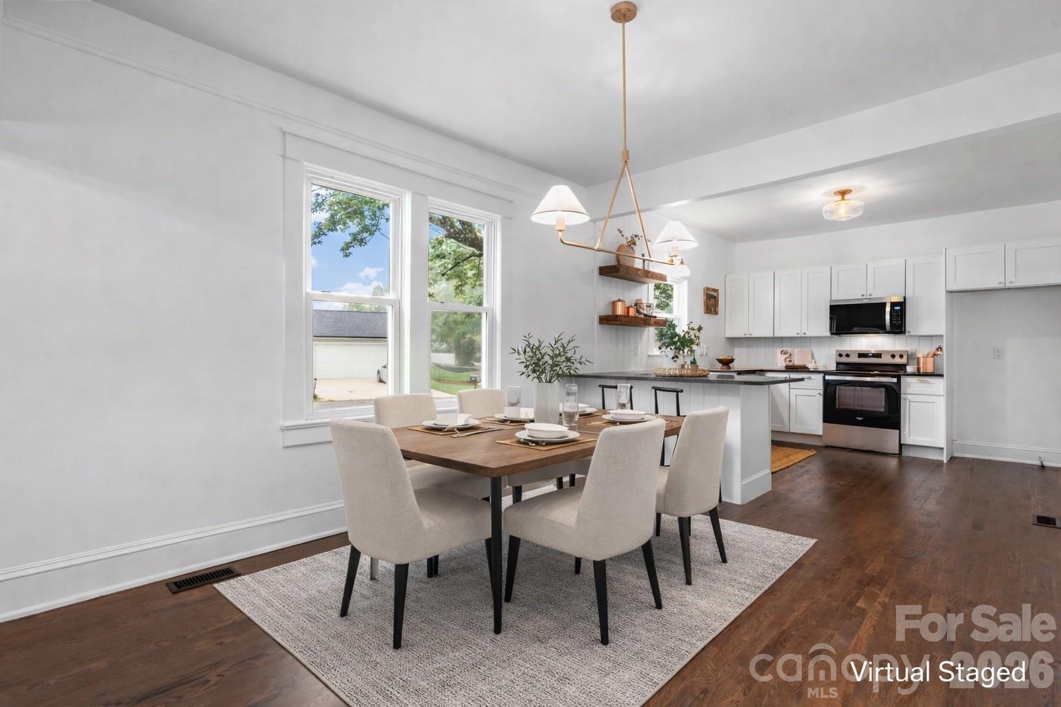 1590 South Center Street Hickory, NC 28602 - Photo 7 of 29 a dining room with wooden floor a chandelier a wooden table and chairs